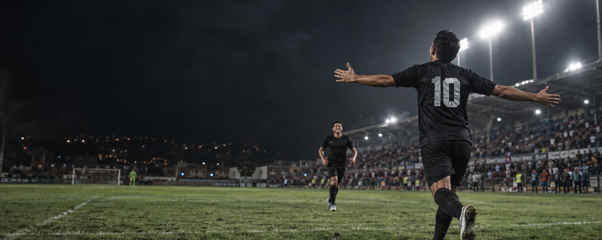 Futbolista celebrando un gol bajo las luces del estadio